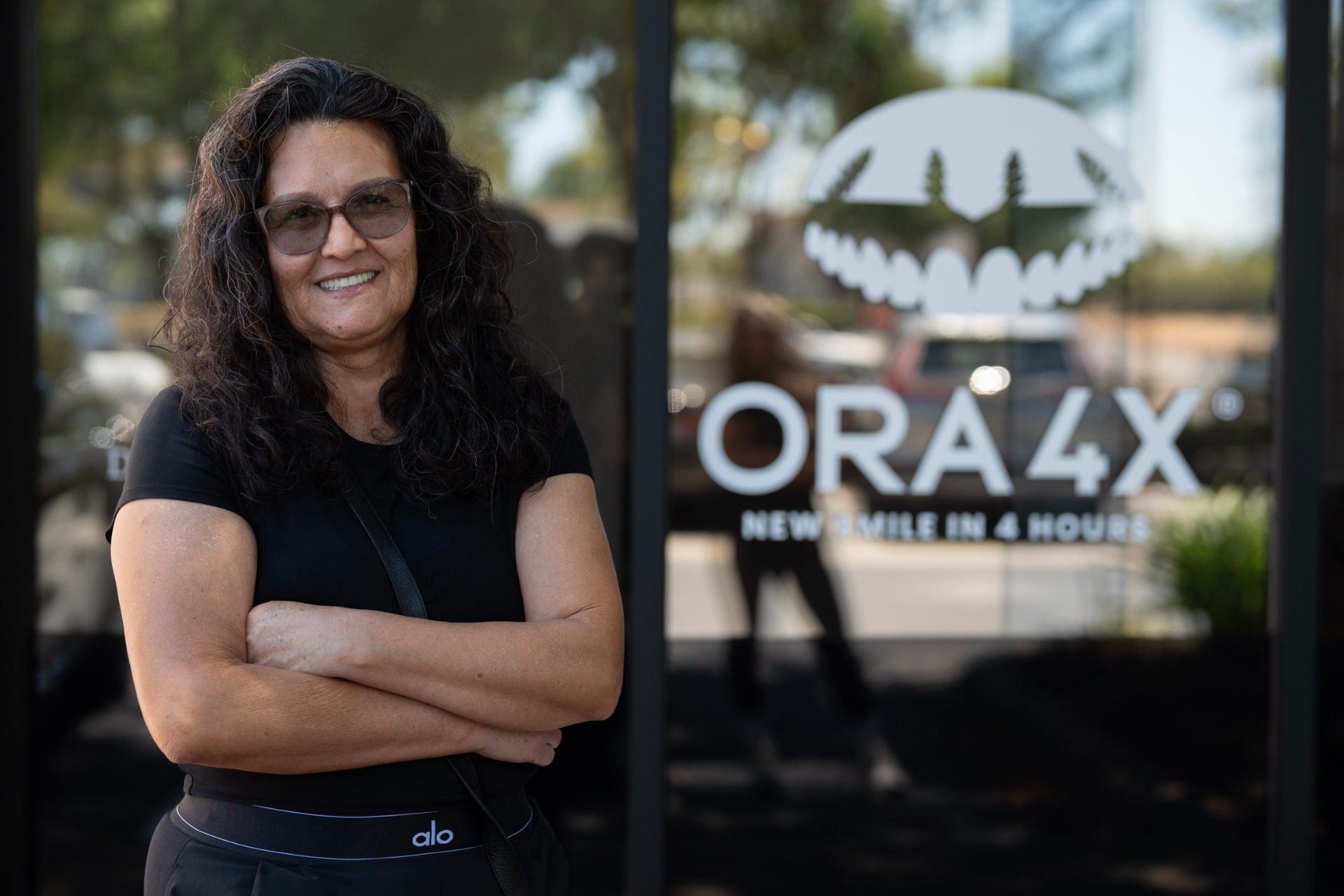 Smiling patient outside the ORA 4X dental implant center in Sacramento